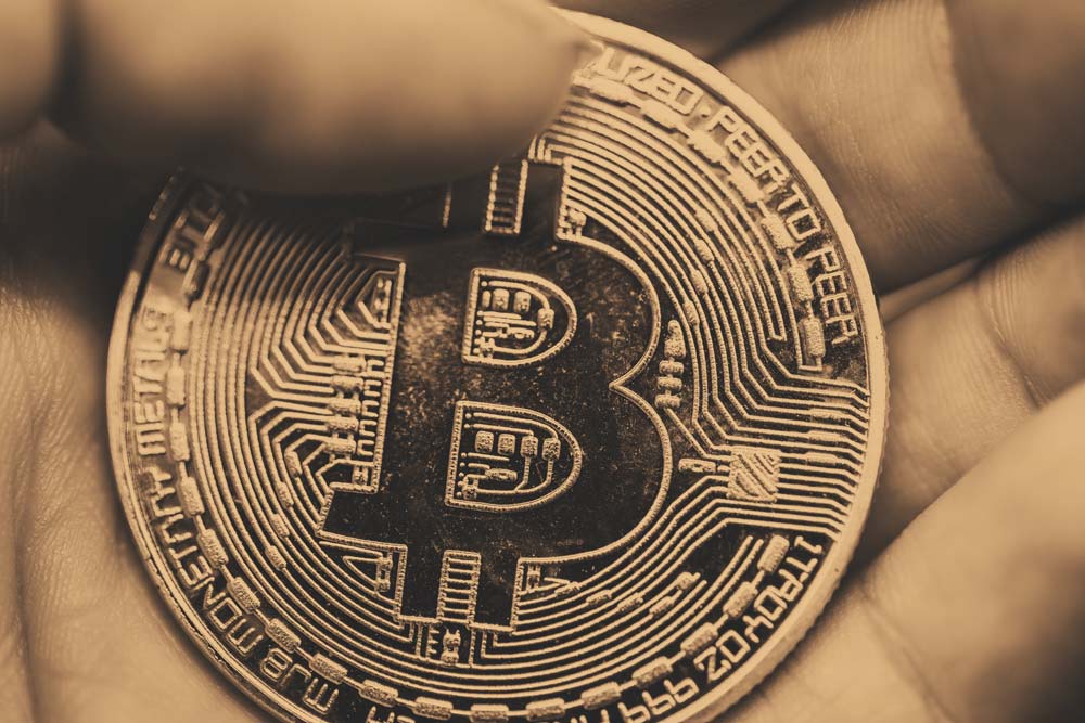 Bitcoin Münze in einer Hand gehalten