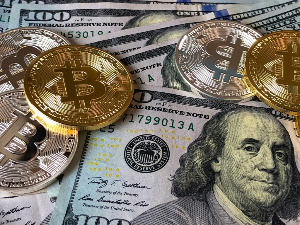 Hundert Dollar Scheine und physische Bitcoin Münzen